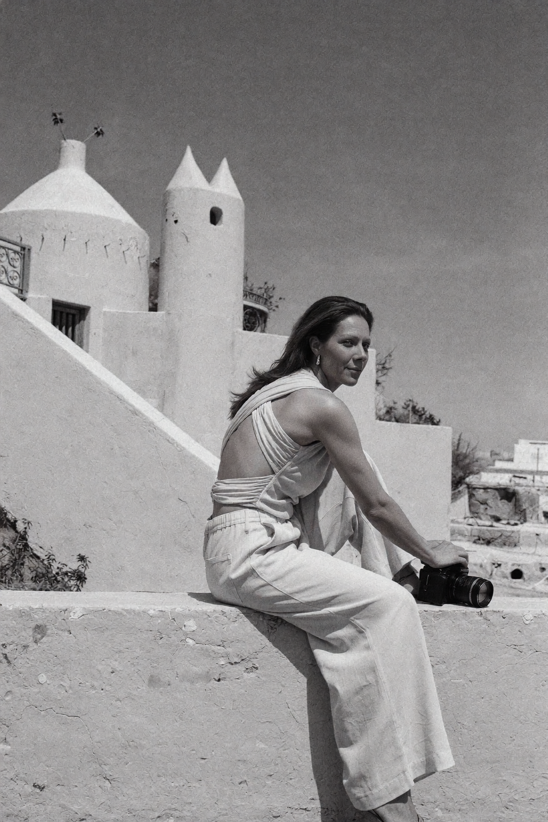 Black-and-white portrait of Olga Poppius seated outdoors with her camera